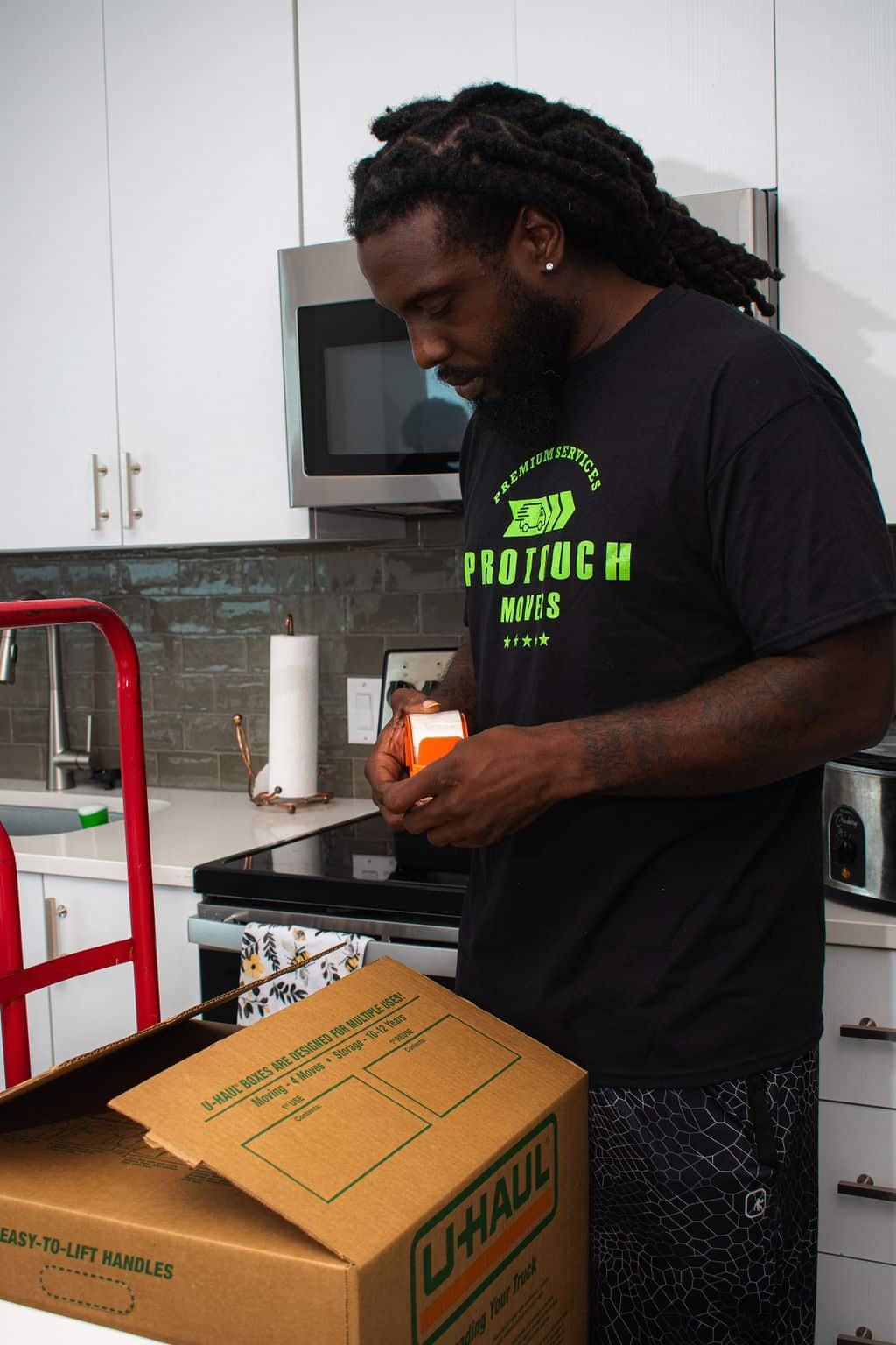 Employee taping a moving box closed