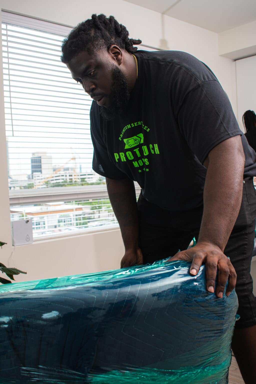 Person handling wrapped furniture indoors. moving company in Orlando. moving company in Atlantic Beach. St Marys