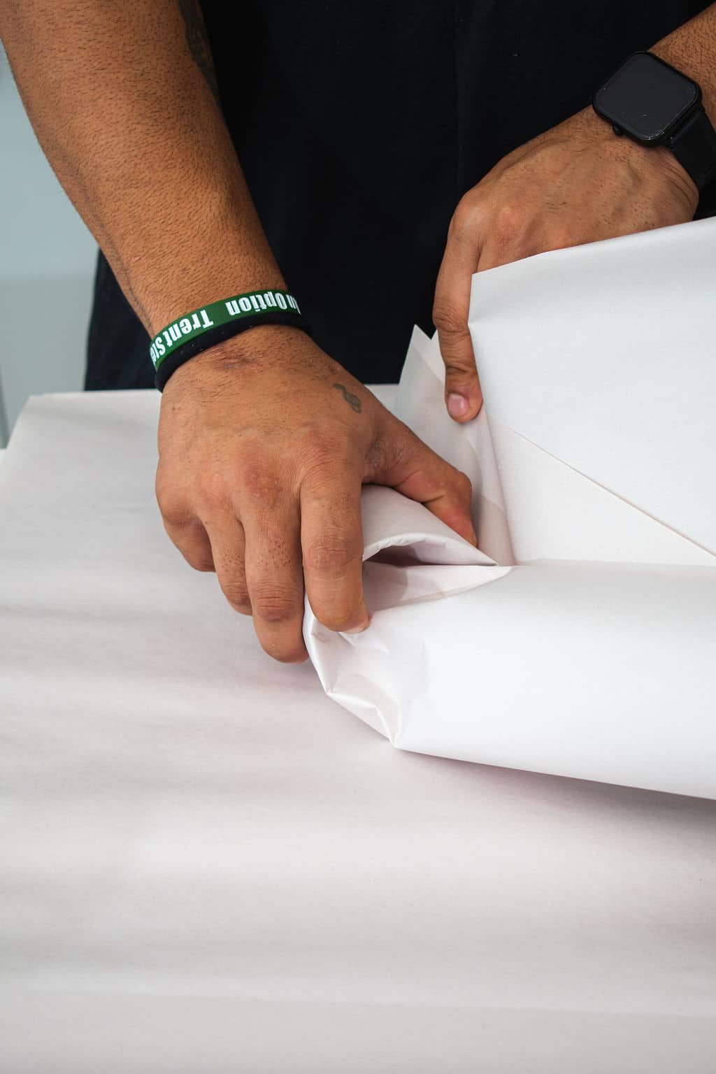 Hands wrapping paper around object. moving company in Tampa