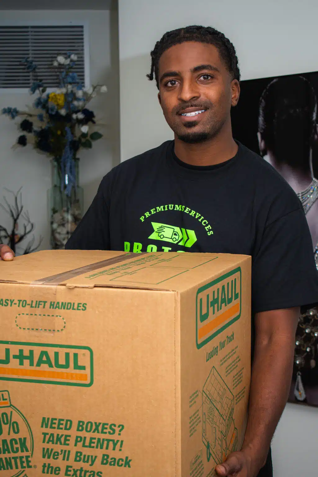 Pro Touch Movers employee holding a box, smiling. moving company in Merritt Island. Contact, appliance moving