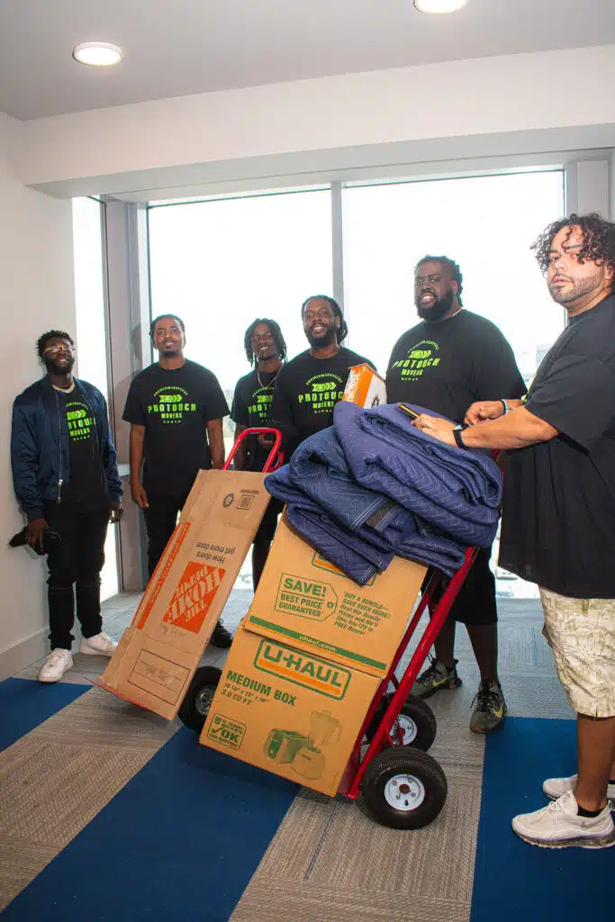 Services 25 Pro Touch Movers team standing in front of a door with moving boxes
