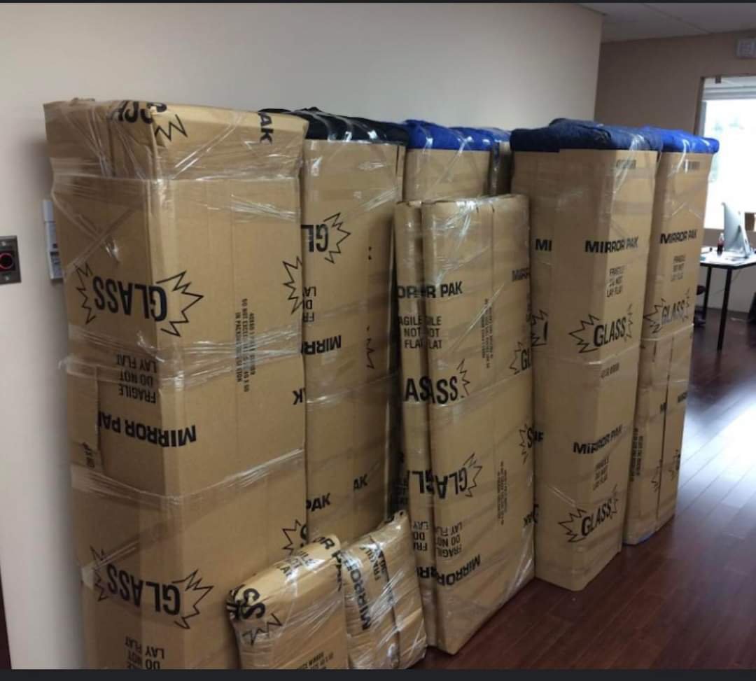 Boxes leaning against a wall with glass inside.