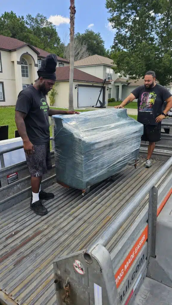 Services 26 Two men loading a piano onto truck. moving company in Middleburg. moving company in Green Cove Springs, piano moving