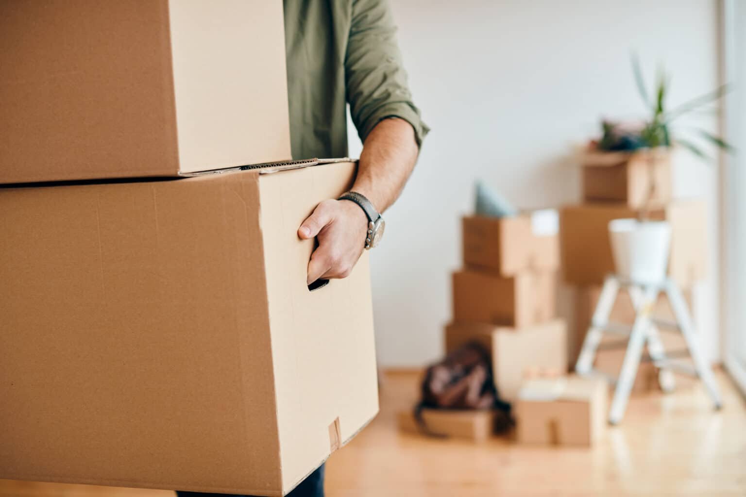 Man carrying boxes into apartment